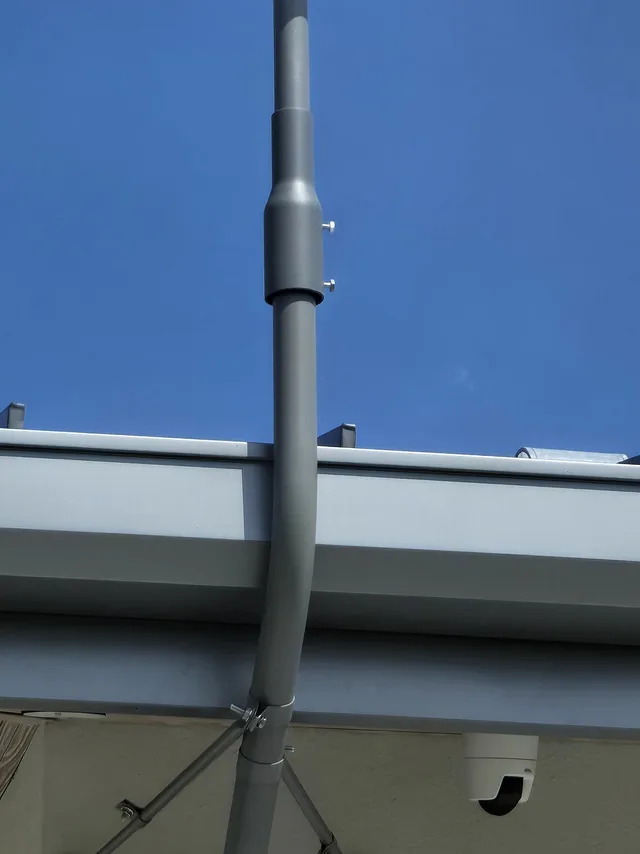 Close view of two dome security cameras under an eave with a wireless antenna mast above them