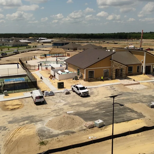 Aerial drone view of a community amenity center under construction with pool and courts, Winter Haven, FL
