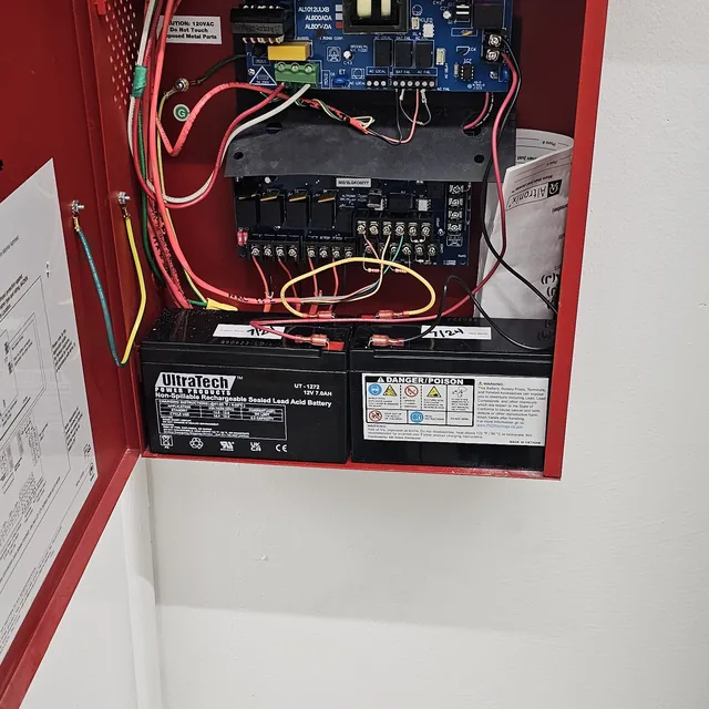 Open Altronix fire alarm power supply with backup batteries and terminated wiring