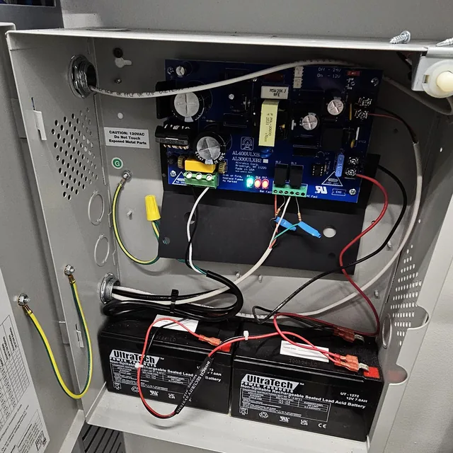 Open Altronix low-voltage power supply enclosure with two backup batteries wired in, Kissimmee, FL