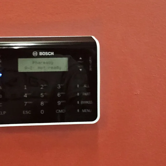Bosch touch keypad for a commercial intrusion alarm system mounted on a red wall, Winter Garden, FL