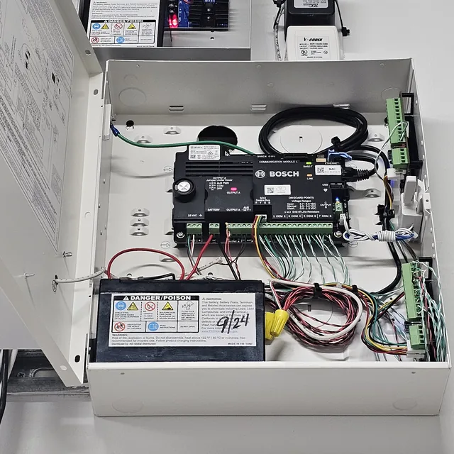 Open Bosch B Series alarm panel with Altronix power supply and transformer mounted above, Clermont, FL