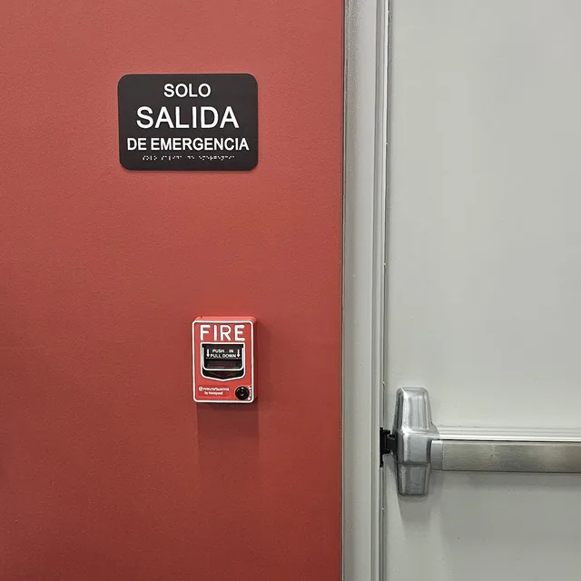 Emergency exit door with panic bar, bilingual exit signage and a fire alarm pull station, Kissimmee, FL