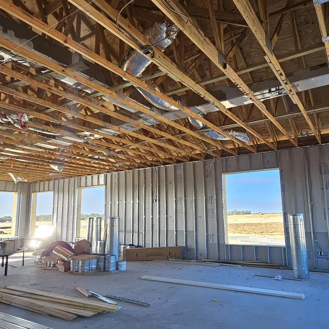 Commercial new construction interior with exposed trusses and ductwork during prewire, Winter Haven, FL