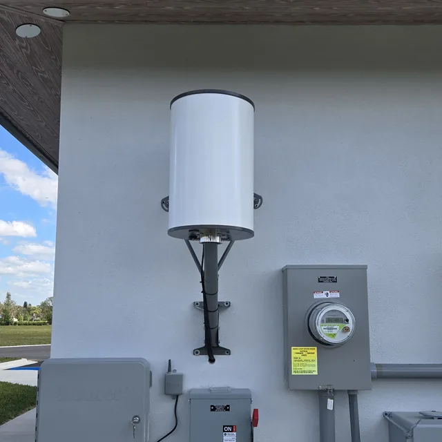 Outdoor wireless antenna wall-mounted beside electrical meters and disconnects, Orlando, FL