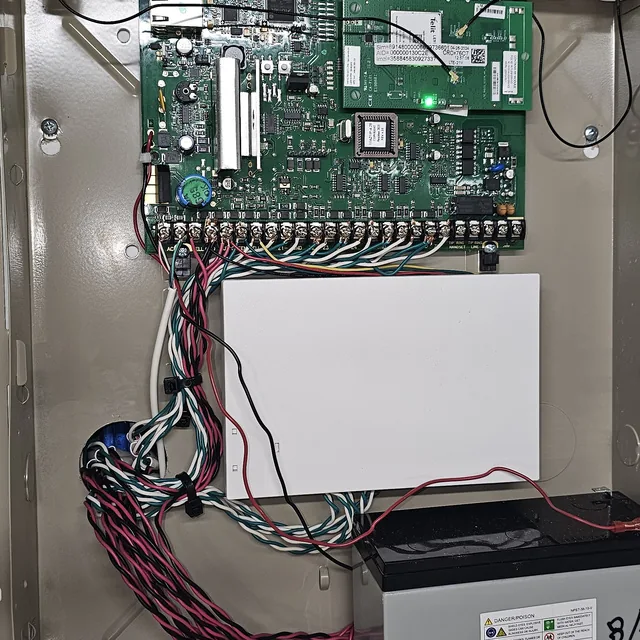 Open security alarm panel with cellular communicator board, dressed zone wiring and backup battery, Clermont, FL