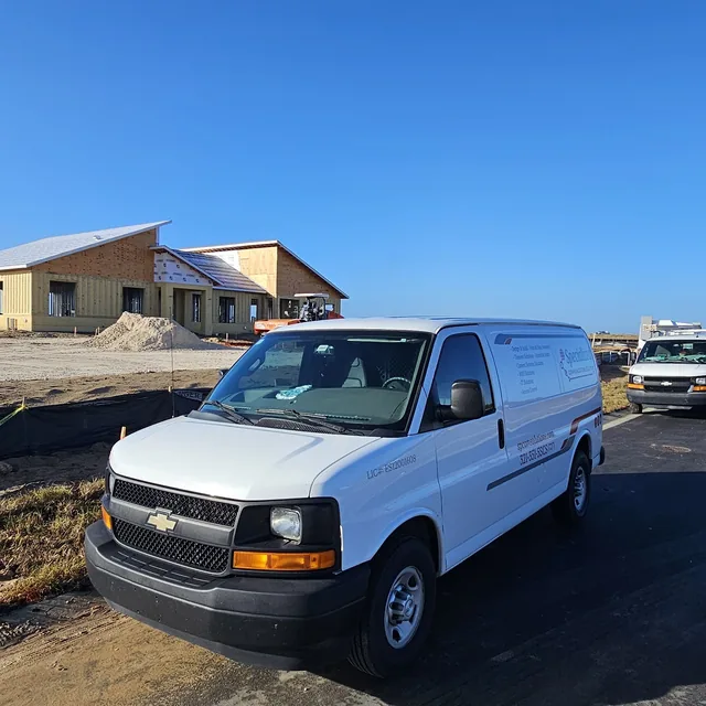 SPCom Solutions service van parked at a new construction jobsite, Winter Haven, FL