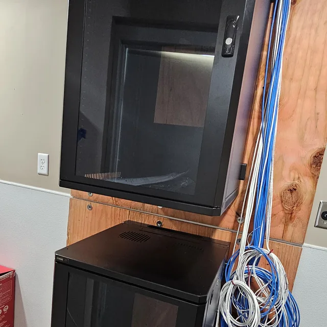 Stacked wall-mount network cabinets with Cat6 cabling roughed in on a plywood backboard, Winter Haven, FL