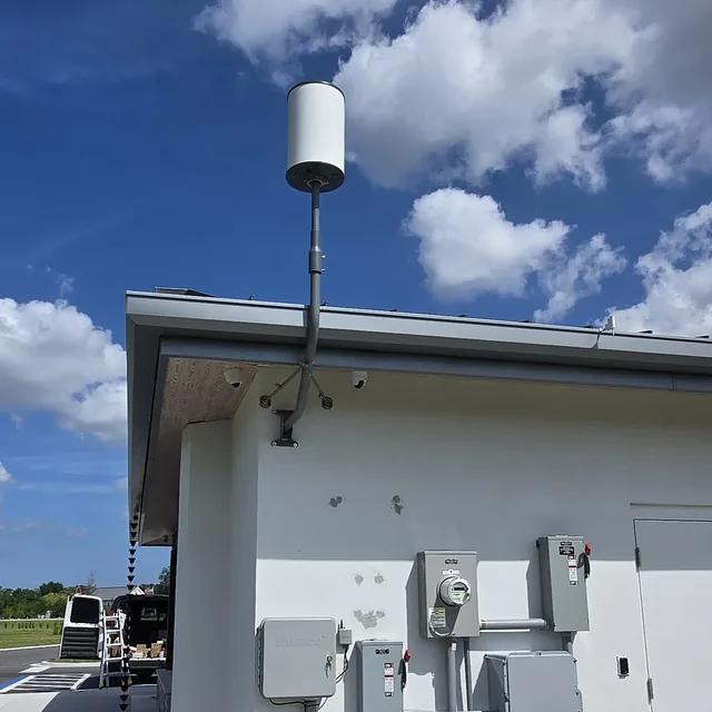Commercial building exterior with a wireless antenna mast and dome security cameras, Orlando, FL