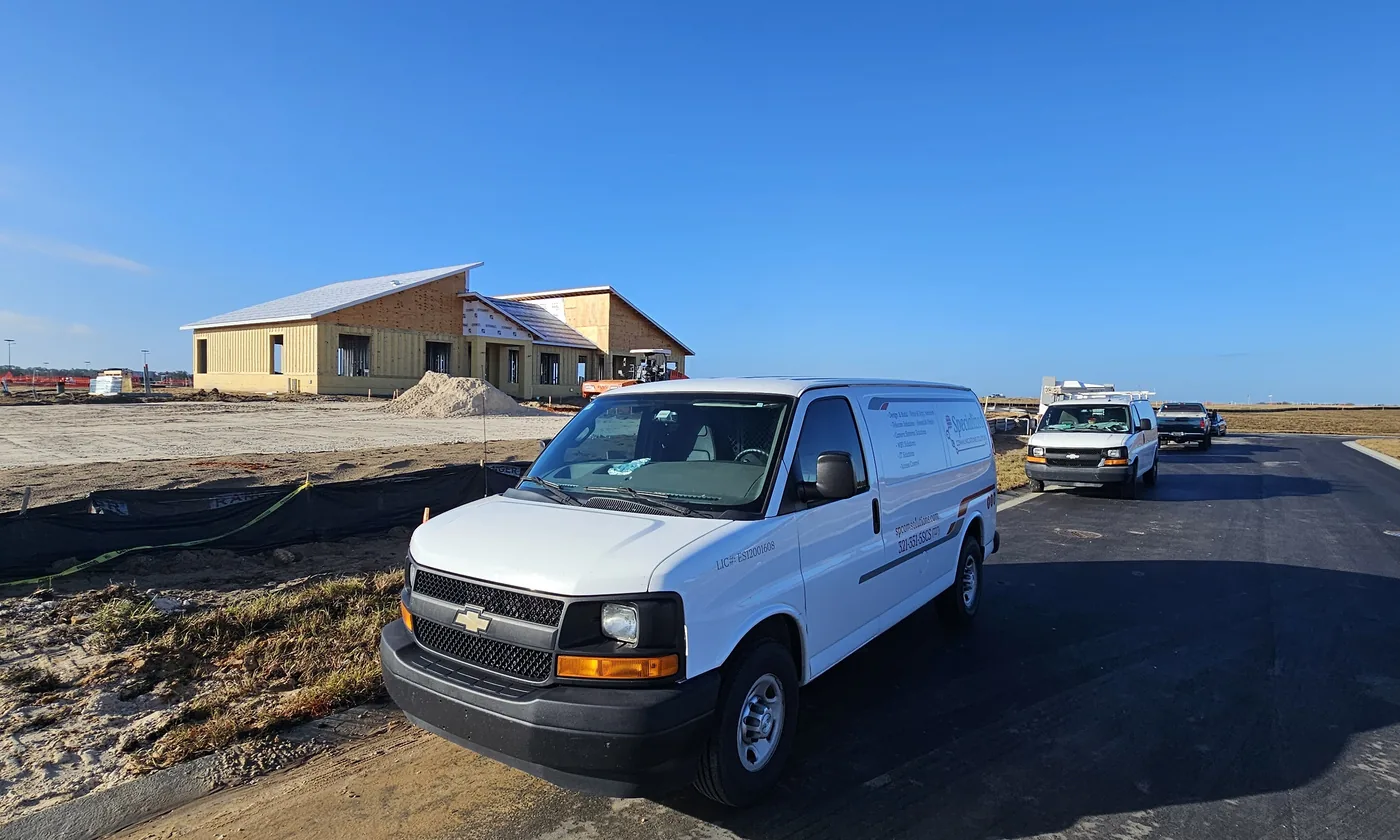 SPCom Solutions service van parked at a new construction jobsite