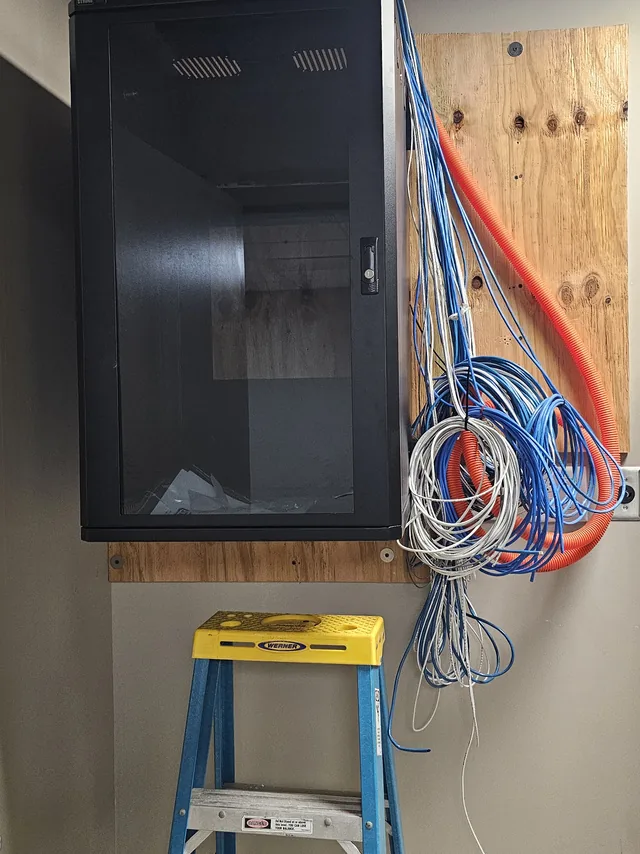 Wall-mount network cabinet with orange fiber innerduct and Cat6 cable roughed in